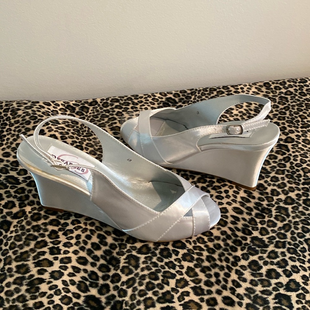 White satin wedge in size 6M   The shoe is 3 inchs The  toe is a peep toe. New